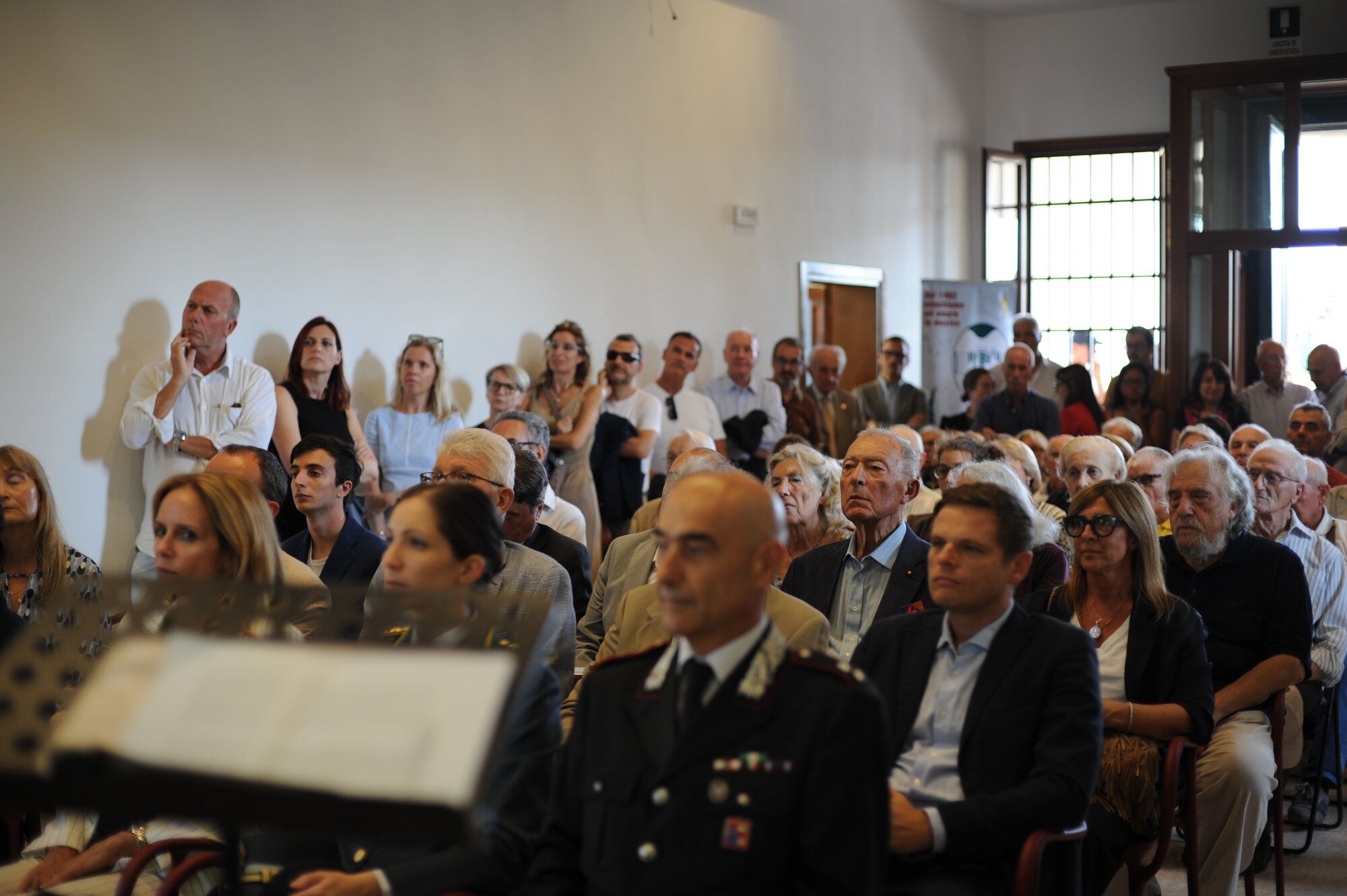 Il pubblico nella sala della villa durante l’inaugurazione